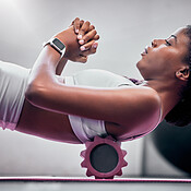 Yoga, floor and black woman with foam roller for massage, healthcare or ...