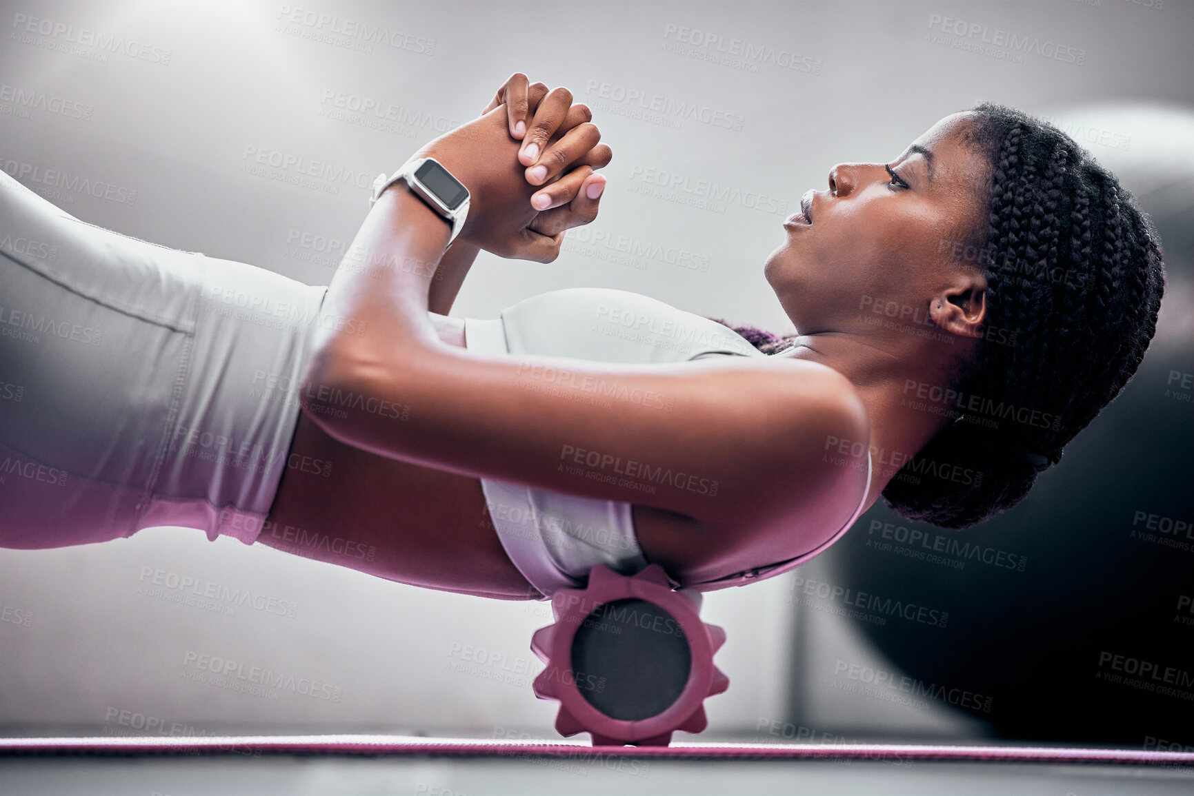 Buy stock photo Yoga, floor and black woman with foam roller for massage, healthcare or back support help in health club, studio or gym. Muscle relief, sports wellness and neon pilates athlete doing fascia exercise