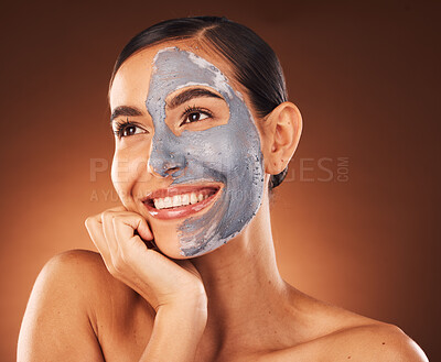 Buy stock photo Face, beauty skincare and woman with clay mask in studio isolated on a brown background. Makeup, aesthetics and happy female from Canada thinking about healthy and glowing skin after facial treatment