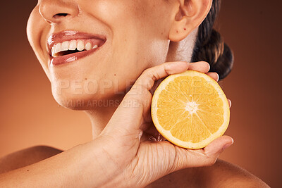 Buy stock photo Face, teeth and skincare of woman with lemon in studio isolated on a brown background. Beauty, wellness and smile of happy female model with citrus fruit for healthy vitamin c, nutrition and minerals