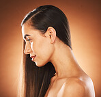 Face, beauty and hair with a model woman in studio on a brown background to promote keratin treatment. Haircare, hairstyle and wellness with an attractive young female posing for natural hair care