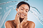 Woman, skincare and beauty for clean hydration, cosmetics or hygiene against a blue studio background. Female model in relax with water splash for facial cleanse or care treatment for skin on mockup