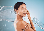 Face portrait, skincare and water splash of woman in studio isolated on a blue background mockup. Shower, cleaning and hygiene of female from Brazil bathing or washing for beauty, wellness and health