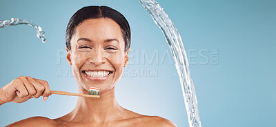 Buy stock photo Black woman, toothbrush and brushing teeth with a water splash and toothpaste on blue studio background for dental health and wellness. Portrait and face of model cleaning mouth with eco brush