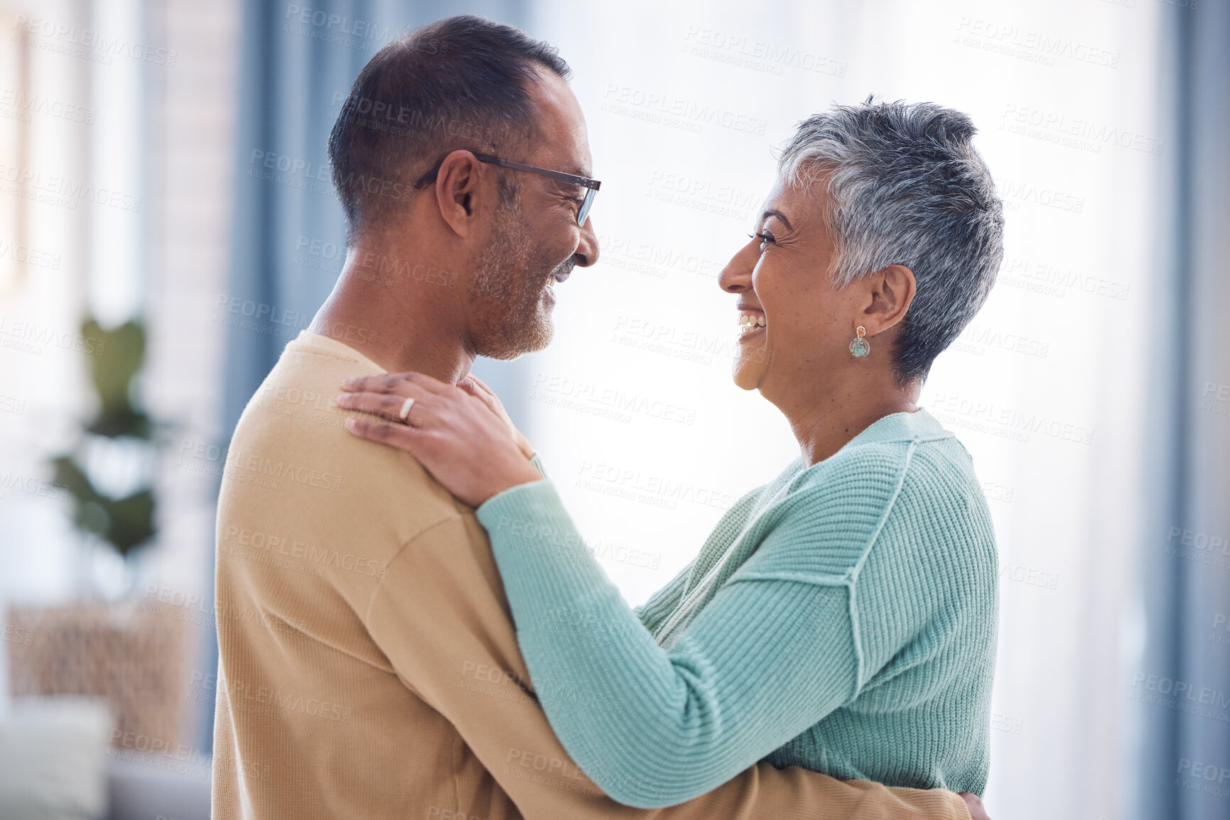 Buy stock photo Happy, love and romance with a senior couple laughing, hugging or dancing together in their home. Dance, romantic and smile with a happy mature man and woman enjoying their retirement while bonding