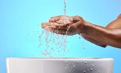 Buy stock photo Cleaning, washing and hands with water in studio on blue background for wellness, hydration and virus safety. Skincare, health and black person washing hands for germ protection, hygiene and bacteria