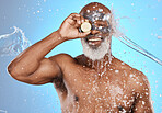 Skincare, charcoal face mask and black man with organic facial, wellness and health against blue studio background. Cosmetics, orange and water splash with senior male, natural beauty and body care. 