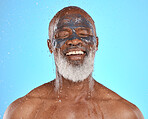 Skincare, water and black man with mask for facial on blue background in studio for wellness, spa and cleanse. Dermatology, cleaning and senior male with face mask, skin treatment and water splash