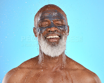 Buy stock photo Skincare, water and black man with mask for facial on blue background in studio for wellness, spa and cleanse. Dermatology, cleaning and senior male with face mask, skin treatment and water splash