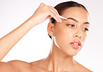 Hair removal, model or woman with a tweezer for eyebrow beauty, skincare or grooming in studio on white background. Wellness, face and young relaxed girl plucking eyebrows in a self care routine 