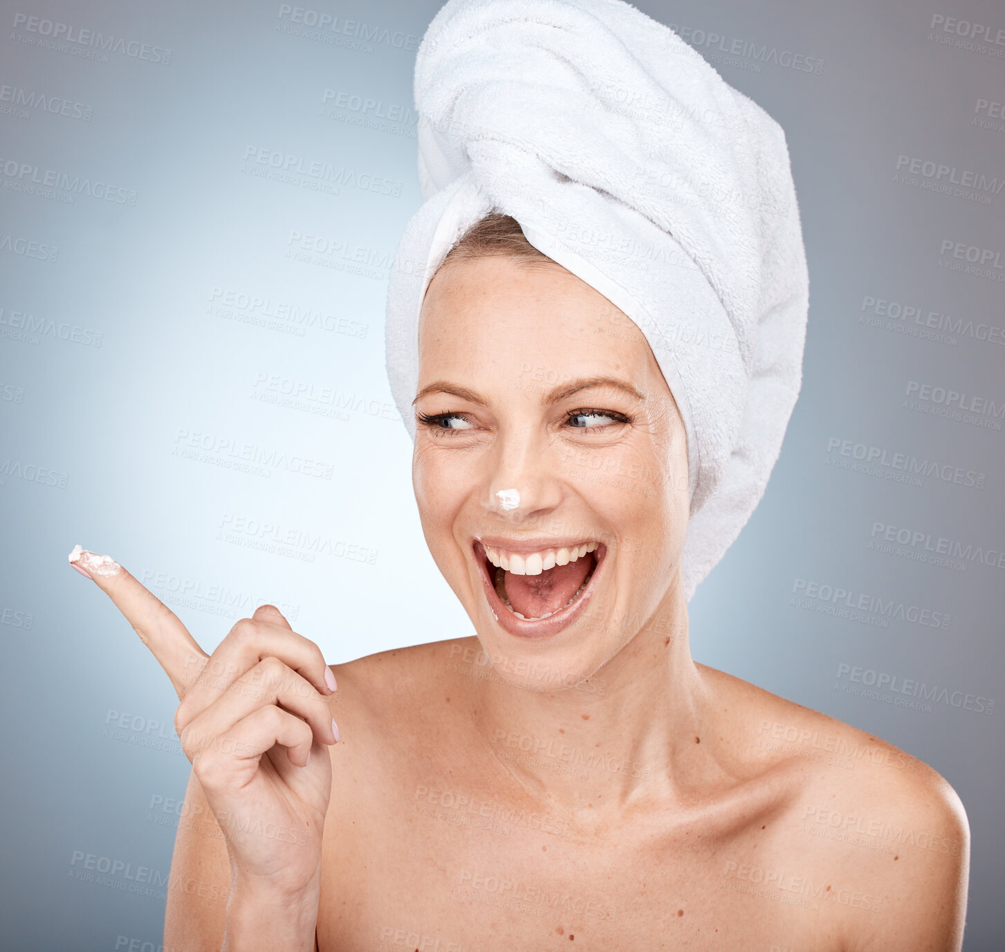 Buy stock photo Beauty, skincare and cream of woman happy with cosmetics for grooming, cleaning or facial treatment. Hygiene cosmetic model with lotion  on clean face or smile in grey studio with mockup after shower