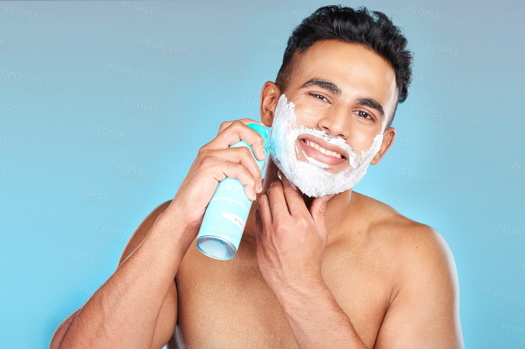 Buy stock photo Skincare, face and man with shaving cream in studio on a blue background. Portrait, hair care or happy male model from Brazil spraying shave gel product for beard grooming, facial cleaning or hygiene