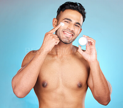 Buy stock photo Portrait, skincare and man in studio with face cream for wellness, pamper and cleaning on blue background. Face, beauty and facial, mask and product on guy model relax,  luxury and grooming mockup