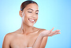 Woman, beauty and brand space with skincare mockup for facial product placement, marketing or advertising on background. Hand, face and happy model in blue studio with dermatology cosmetics or logo