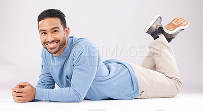 Buy stock photo Fashion, portrait and happy man on the floor in studio isolated on a white background. Style, smile and Asian person from Cambodia in casual clothes, trendy aesthetic or confidence to relax on ground