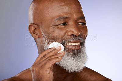 Buy stock photo Face, skincare and antiaging with a senior black man exfoliating his skin in studio on a gray background. Beauty, cleaning and cleansing with a mature male using a cotton pad for natural treatment
