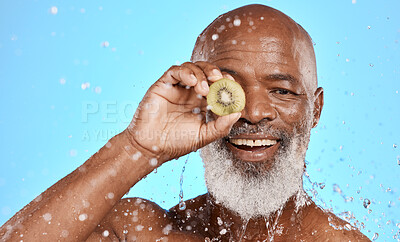 Buy stock photo Kiwi, black man and cosmetics for wellness, spa and water splash for skincare, smile and body care on blue studio background. Male, senior guy and fruit for natural beauty, drops or clean for hygiene