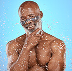 Water, shower and skincare with a model black man in studio on a blue background for hygiene or hydration. Water splash, wet and beauty with a senior man in the bathroom for antiaging treatment