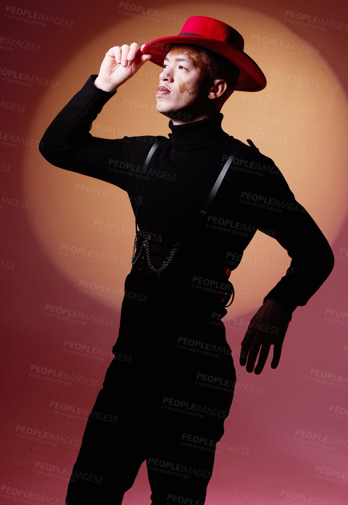 Buy stock photo Fashion, aesthetic and black man with vitiligo in studio isolated on a red background. Beauty, creative pose and stylish male model posing in designer hat, trendy and luxury clothing on a backdrop.
