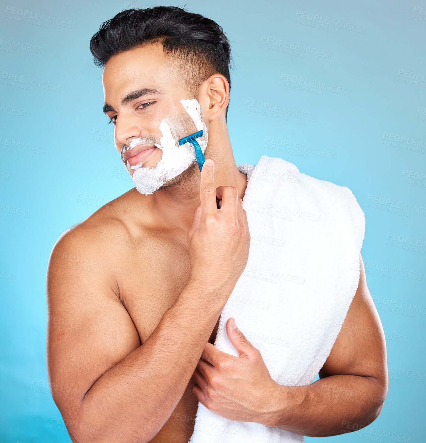 Buy stock photo Man, shaving face and studio for wellness, skincare and towel with happiness by blue background. Model, facial hair removal and cosmetic foam for skin, self care and beauty with cosmetics by backdrop