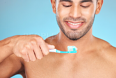 Buy stock photo Toothbrush, toothpaste and man happy brushing teeth for dental care, morning hygiene and cleaning in studio. Smile, tooth whitening and mouth healthcare or oral care happiness in blue background