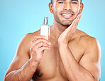 Cologne, grooming and face of a man for skincare, beauty wellness and luxury cosmetics against a blue background in studio. Self care, smile and portrait of a model with facial perfume product