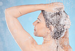 Back, shower and woman with foam, hygiene and natural beauty against blue studio background. Young female, girl and washing for body care, confident and skincare for morning routine, relax and water.