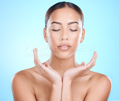 Buy stock photo Skincare, hands and face of woman in studio for natural healing, youth glow and skin wellness on blue mockup for marketing. A young beauty model, facial cosmetics and makeup promotion for dermatology