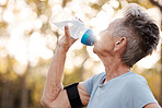 Senior woman runner, drinking water and workout in park, summer and training for health, cardio and fitness. Elderly running, exercise and hydration with water break for healthy body, mind or muscle