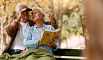 Happy senior couple bird watching in park for relax bonding time together, freedom and retirement peace on outdoor bench. Elderly marriage love, binoculars and book reading woman with man pointing