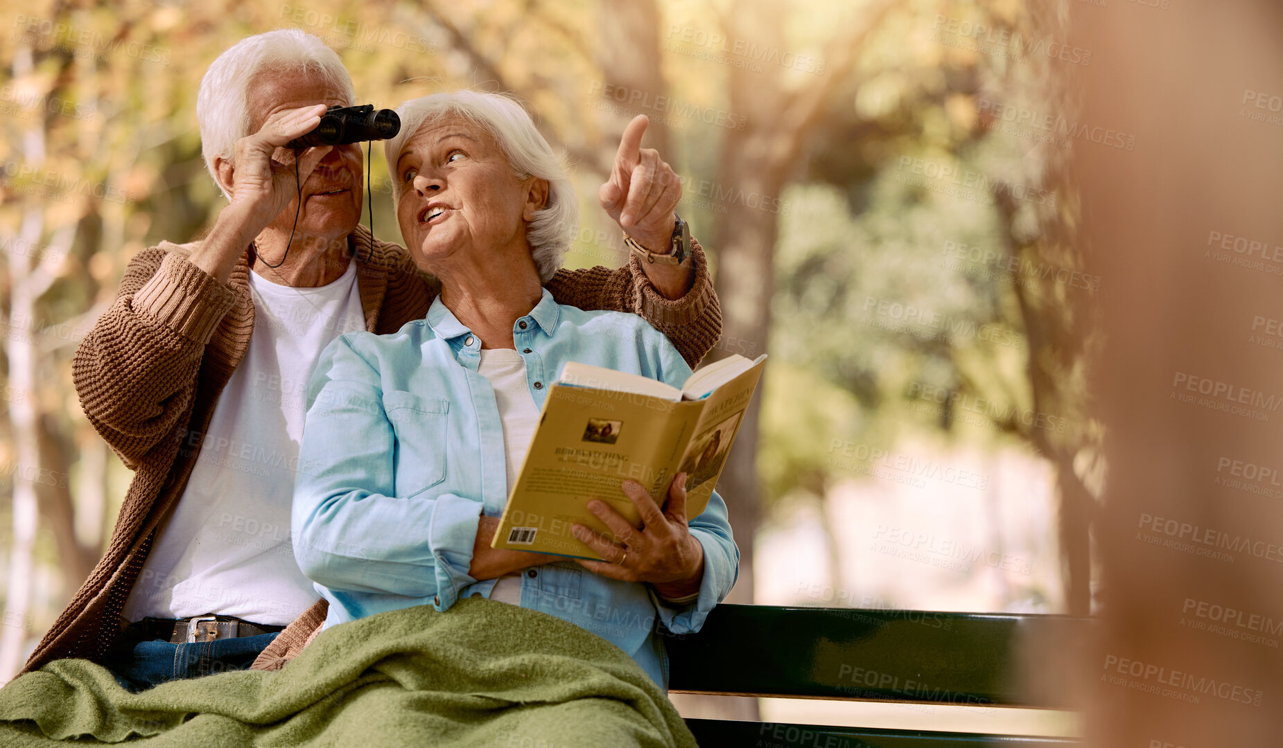 Buy stock photo Happy senior couple bird watching in park for relax bonding time together, freedom and retirement peace on outdoor bench. Elderly marriage love, binoculars and book reading woman with man pointing