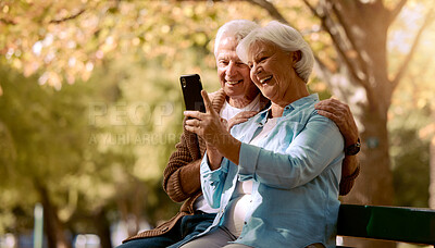 Buy stock photo Senior couple, selfie and smile in park, happy and trees by blurred background for social media. Elderly man, old woman and smartphone on park bench for happiness photo, love or video call in Quebec