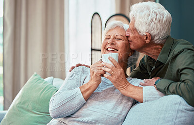 Buy stock photo Kiss, coffee and senior couple laughing, talking and smile during retirement in the living room of their house. Relax, love and elderly man and woman with affection, tea drink and comic conversation