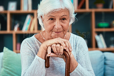 Buy stock photo Thinking, cane and retirement with a senior woman sitting on a sofa in the living room of her home alone. Idea, disability and walking stick with a mature female pensioner in her house to relax