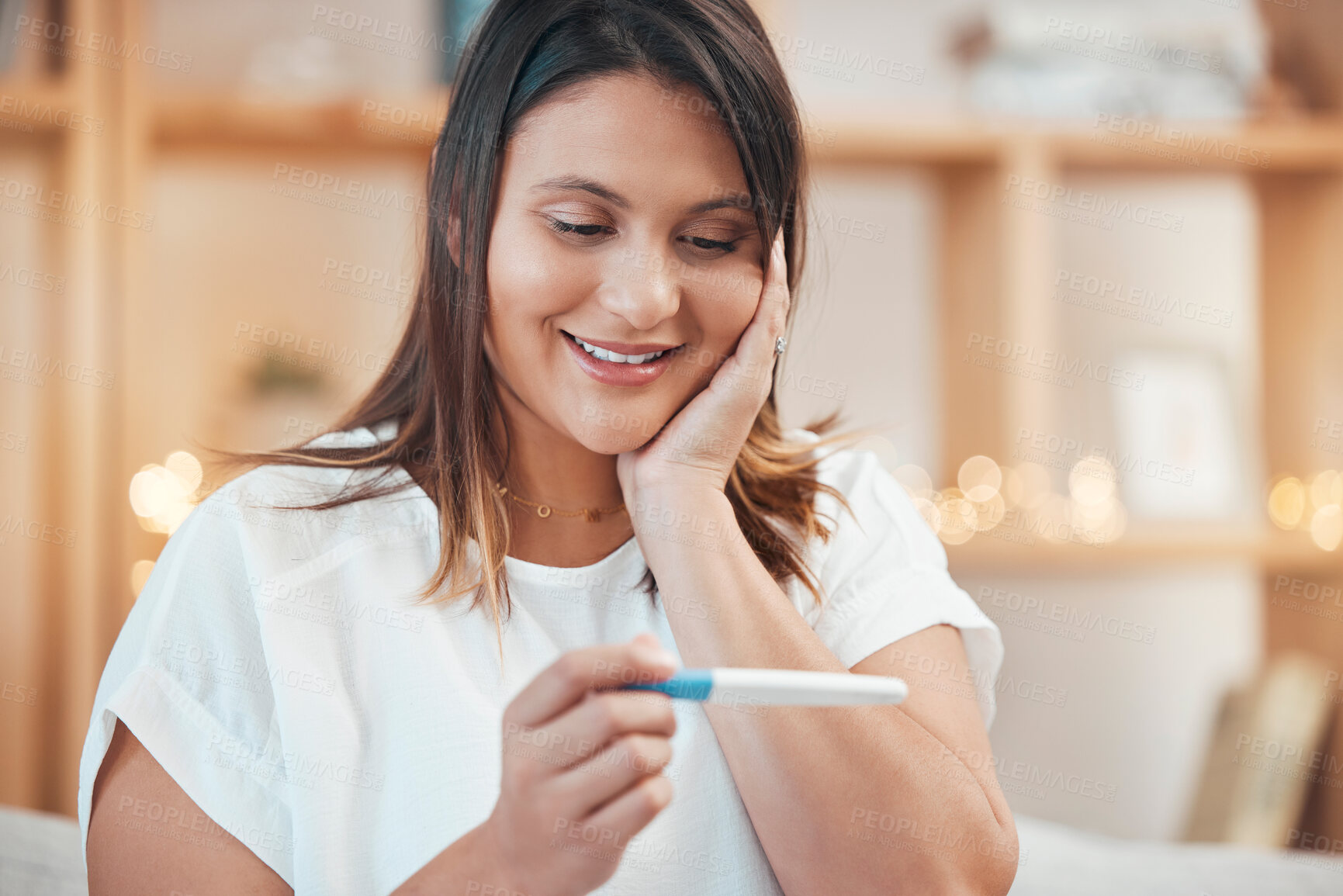 Buy stock photo Wow, pregnancy test results and indian woman on sofa of living room at home with happy surprise, good news and smile. Healthy future mom, pregnant and testing stick with omg eyes, happiness and shock