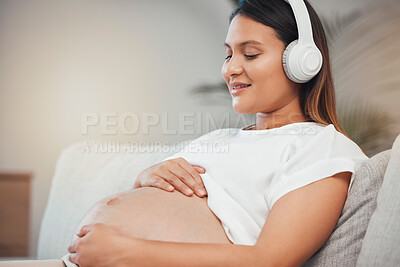 Buy stock photo Woman, pregnant and relax while listening to calm music on sofa in healthy zen, wellness or meditation at home. Pregnant woman smile in relaxation holding tummy with headphones on living room couch