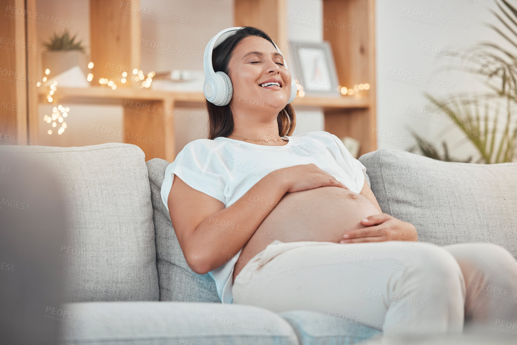 Buy stock photo Pregnant woman, relax and headphones for listening to music on sofa for healthy zen, calm and peace for wellness or soothing at home. Happy female with pregnancy tummy on living room couch to rest