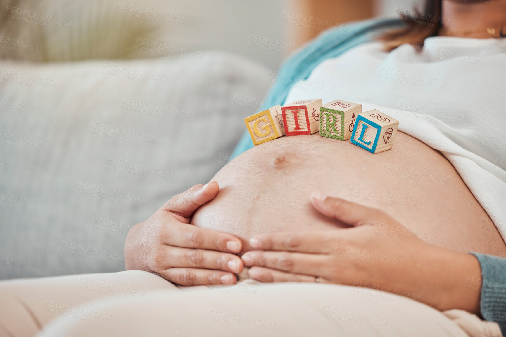 Buy stock photo Pregnant woman, stomach and baby blocks in home for girl announcement on sofa in living room. New mother, parenthood love and childcare or pregnancy support, relax and calm mom with hands on belly