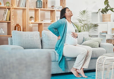 Buy stock photo Pregnant, woman and back pain with a mother feeling painful body while sitting on her couch. Ache, inflammation and pregnancy with a maternity female with physical strain in her back at home