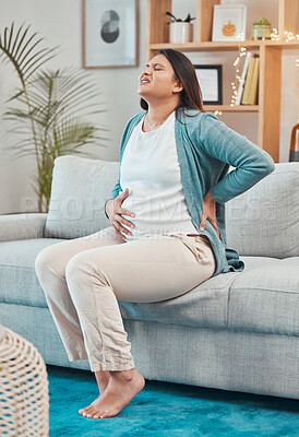 Buy stock photo Pregnant, back pain and woman with ache and body strain while sitting on her living room sofa. Belly, anatomy and pregnancy discomfort with a painful mother unhappy with physical condition at home