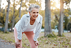 Tired, happy and senior woman running in outdoor nature park for retirement health, wellness and fitness workout. Healthcare exercise, path and runner with fatigue training for elderly marathon race 