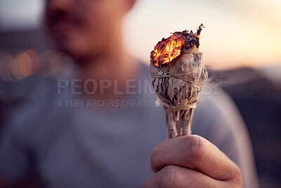 Buy stock photo Man, hand and burning sage for a spiritual meditation on the beach at sunset for health and wellness. Smudge, burn herb and alternative healing ceremony to cleanse chakra in a meditating cleansing