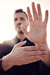 Man, hands and tai chi pose outdoor while training for health, wellness or fitness. Karate sports, martial arts or male athlete practicing fighting technique outside for workout, practice or exercise