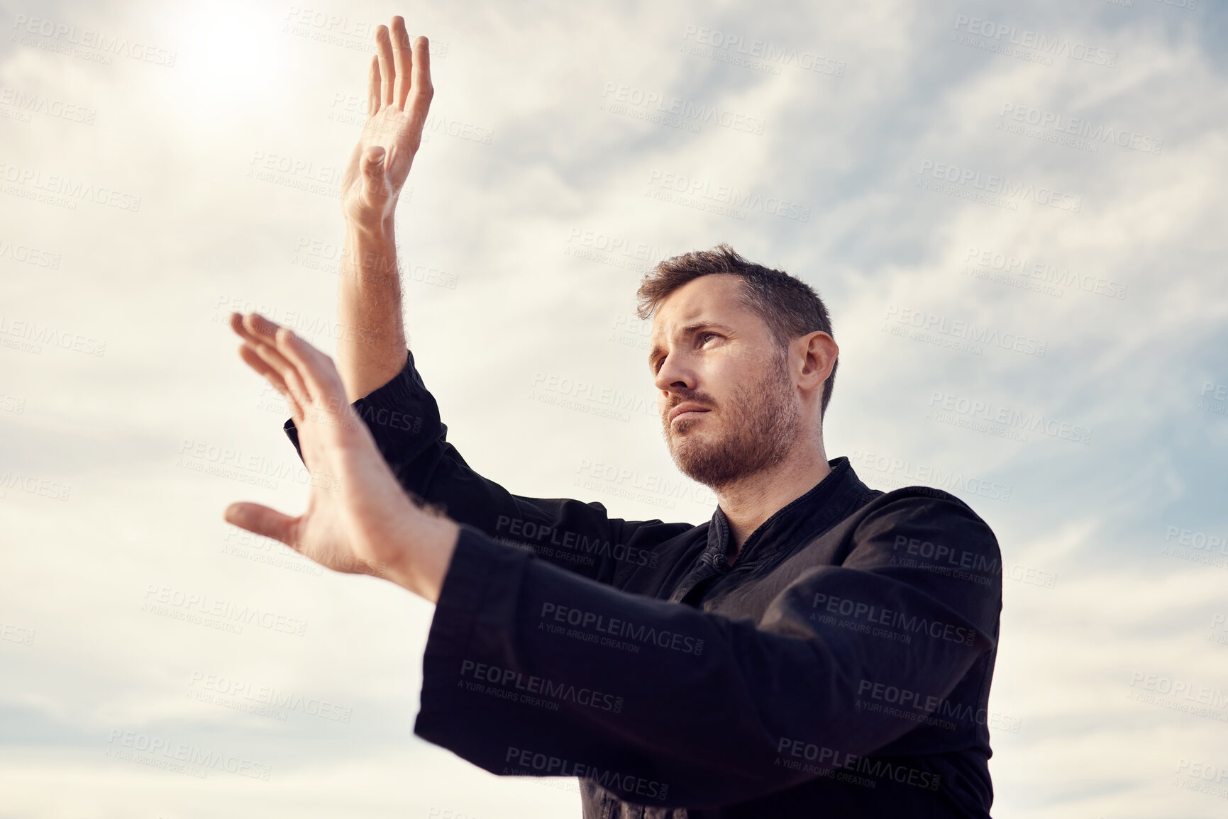 Buy stock photo Karate man, fitness and exercise against a cloudy sky with lens flare for spiritual workout, martial arts and training outdoor. Athlete male ready to fight tai chi, chi gong or taekwondo with hands