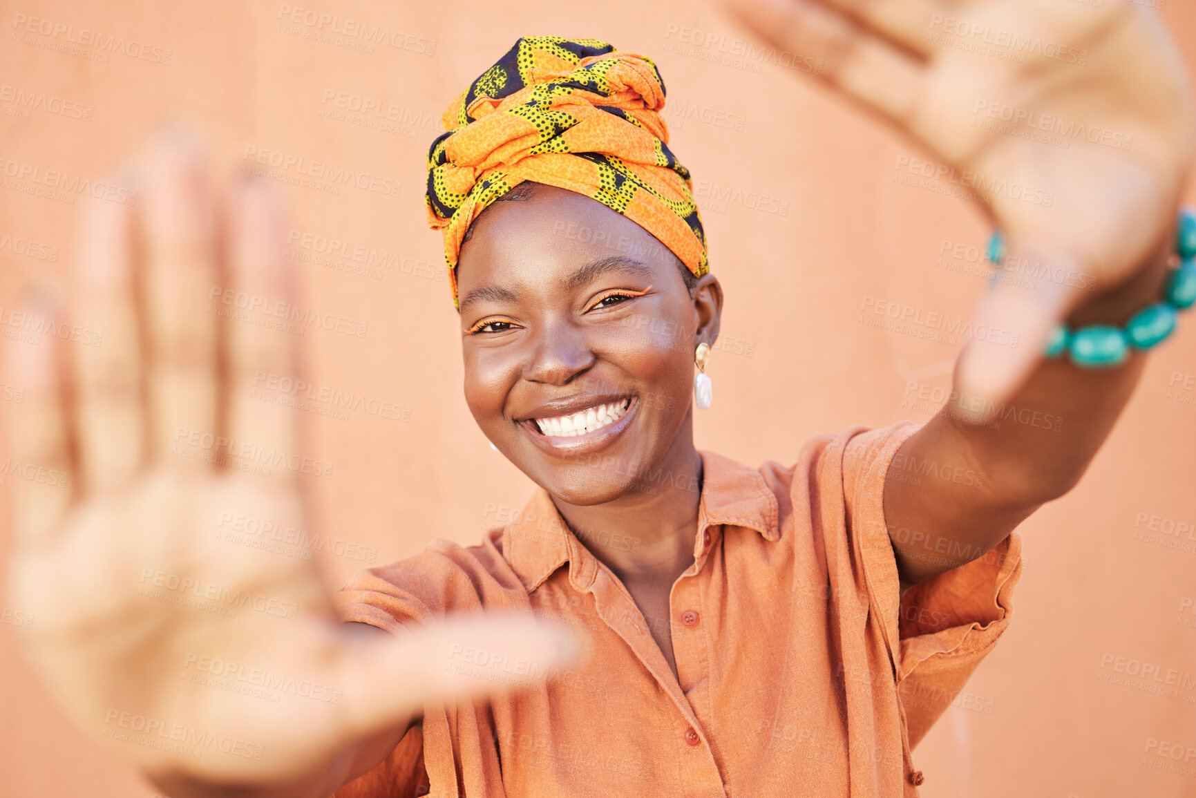 Buy stock photo Fashion black woman, face or framing hands on orange wall background in city for profile picture, Congo branding or clothing advertising. Portrait, smile or happy model in photography pov with turban