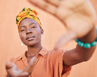 Buy stock photo Black woman, face portrait and hands frame for fashion aesthetic, african culture and turban in studio with orange background. Nigeria, cosmetics makeup and traditional head scarf or playful gesture