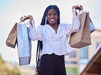 Black woman, retail and shopping portrait in city with excited smile holding purchase bags on weekend. Happy, consumerism and young girl with shopper sale, discount and deal in Los Angeles, USA.