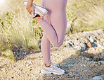 Fitness, woman and stretching leg for running exercise, workout or training in the nature outdoors. Active female runner in warm up stretch or preparation for rocky run, trekking or hiking trail
