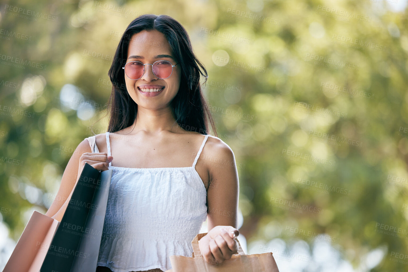 Buy stock photo Woman, fashion and shopping with a smile while outdoor with a green background after buying retail products on sale, promotion and discount. Face portrait of a happy customer with consumer bags