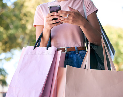 Buy stock photo Hands, phone and shopping bags with a woman customer outdoor in a park during summer for consumerism. Ecommerce, online shopping and retail with a female consumer using the internet to search a sale